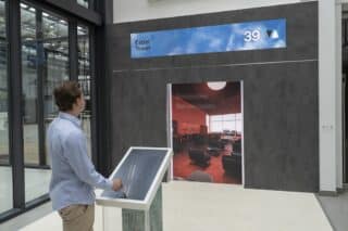 Mann vor Screen unternimmt virtuelle Aufzugfahrt durch den Estrel Tower Berlin